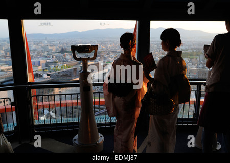 Frauen im Yukata (Sommer-Kimono) Blick auf Sonnenuntergang Lichter über der Stadt. Aussichtsplattform des Kyoto Tower. Kyoto. Japan Stockfoto