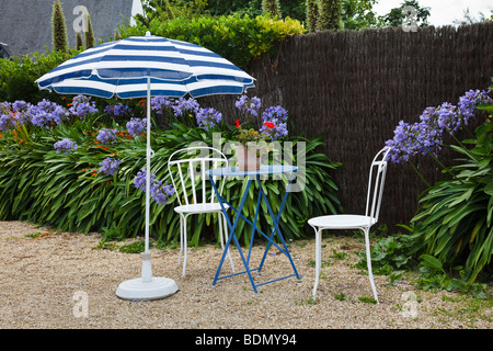 Tisch und Stühle im Garten von einem französischen Café auf der Ile de Bréhat, Bretagne Stockfoto