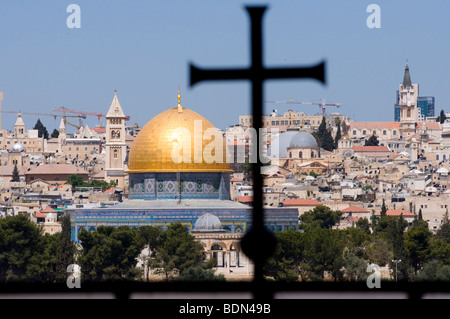 Die Altstadt von Jerusalem und die Haube des Felsens, mit der Silhouette eines Kreuzes in das Fenster des Dominus Flevit-Kapelle zu sehen. Stockfoto