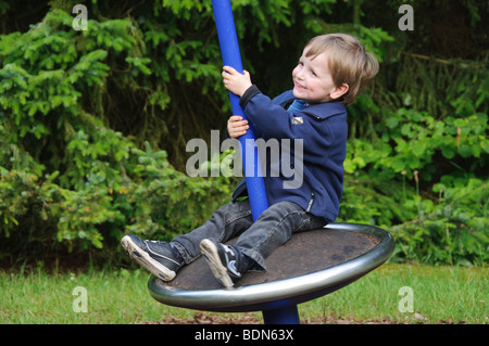 Kleiner Junge, 2 Jahre, sitzt auf einem Karussell, Deutschland Stockfoto