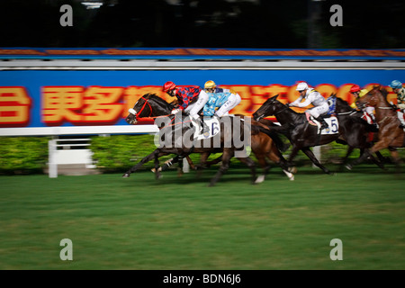 Eine endgültige Galopp bis zum Ziel in einer Nacht Pferd Rennveranstaltung in Happy Valley Pferderennbahn in Hong Kong. Stockfoto