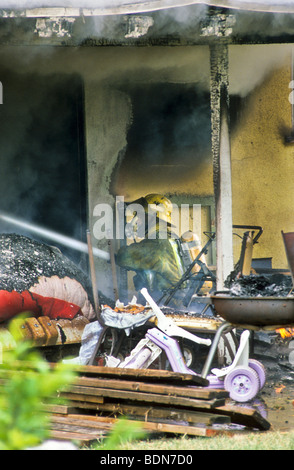 Haus Dachschindel Auto Rauch Flamme Brandgefahr, dass Risiko Maske Helm Sauerstoff Tank Schlauch Spray löschte Feuerwehrmann kämpfen zu löschen Stockfoto