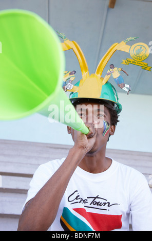 Sport-Fan mit südafrikanischen Flagge gemalt an der Wange eine Vuvuzela bläst. Kapstadt, Westkap, Südafrika Stockfoto