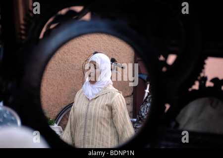 Marokkanische muslimische Frau mit islamischem Kopfschal, Kopftuch oder Hijab spiegelt sich im Spiegel des Marktstandes in Marrakesch, Marokko Stockfoto