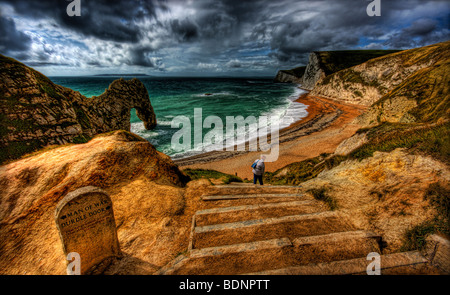 Unven Stufen führen hinunter zu Durdle Door, Dorset. White Water Rock Torbogen verlassen Algen Schmutz am Strand durchbrechen Stockfoto