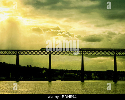 Ein Zug und Brücke Silhouette gegen ein bewölkter Himmel Stockfoto