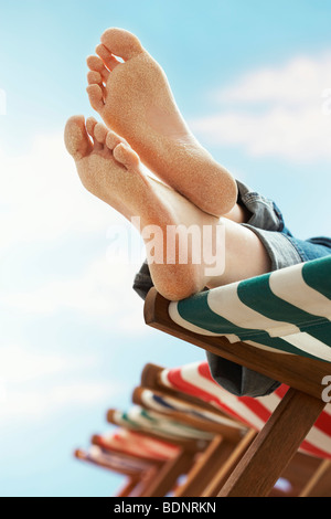 Person ruht auf Liegestuhl am Strand, niedrige Abschnitt Nahaufnahme von Füßen Stockfoto