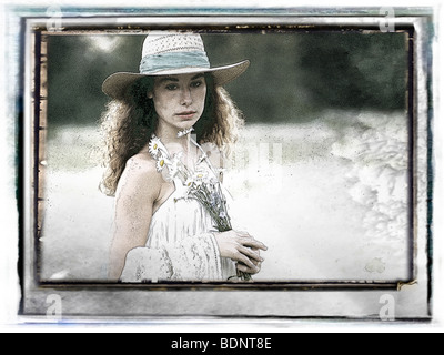 Eine junge Frau trägt einen Strohhut mit Gänseblümchen Stockfoto