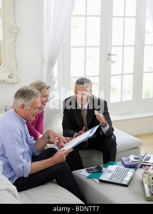 Älteres Paar auf Sofa mit Finanzberater, erhöhten Blick Stockfoto