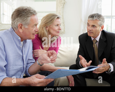Älteres Paar auf Sofa mit Finanzberater Stockfoto