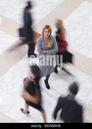 Business-Frau stehend unter Menschen gehen, erhöht, Ansicht, Langzeitbelichtung Stockfoto