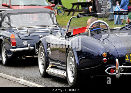 Blaue AC Cobra Oldtimer auf der Straße & im Verkehr mit anderen Oldtimern. Stockfoto