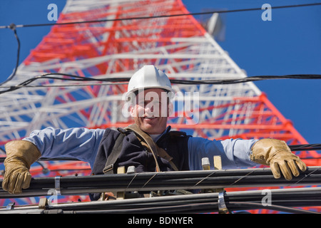 Niedrigen Winkel Blick auf ein Kabel Lineman Reparatur Übertragungsleitung Stockfoto