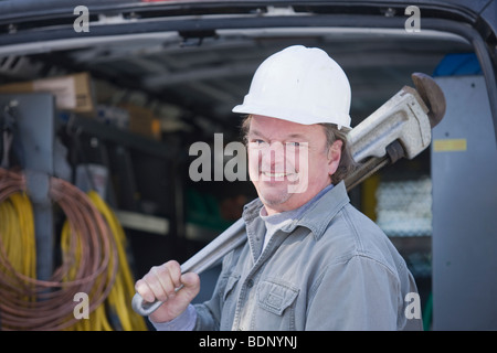 Klempner hält eine Rohrzange Stockfoto