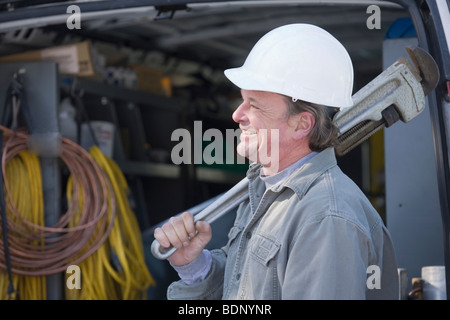 Klempner hält eine Rohrzange Stockfoto