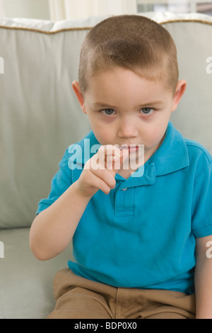 Junge, die Unterzeichnung der Buchstabe "R" in amerikanischer Gebärdensprache Stockfoto