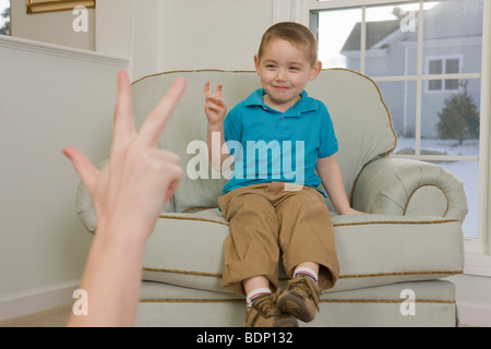 Junge Unterzeichnung die Zahl "3" in amerikanischer Gebärdensprache Stockfoto