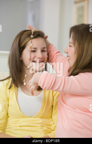 Teenager-Mädchen auf eine Kette auf ihre Schwester Stockfoto