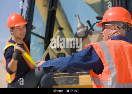 Zwei Ingenieure ein Bagger in einem Werk in Betrieb Stockfoto