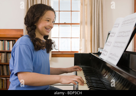 Mädchen lesen ein Notenblatt und ein Klavier spielen Stockfoto