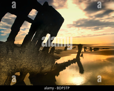 Schiffbruch am Strand bei Sonnenaufgang Stockfoto