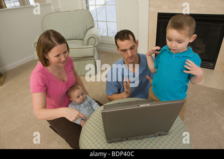 Junge Unterzeichnung das Wort "Urlaub" in amerikanischer Gebärdensprache sitzend mit seiner Familie Stockfoto