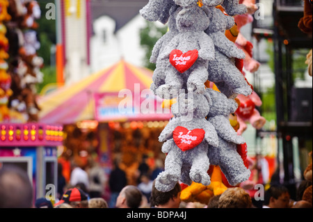 Kuscheltiere mit Herzen sagen: 'Ich liebe dich' hängen an einem Stand auf einem Rummelplatz Stockfoto