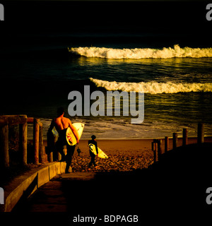 Surfer am Strand halten Surfbretter Stockfoto