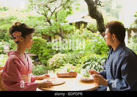 Junges Paar in Kimono mit Mittagessen im offenen café Stockfoto