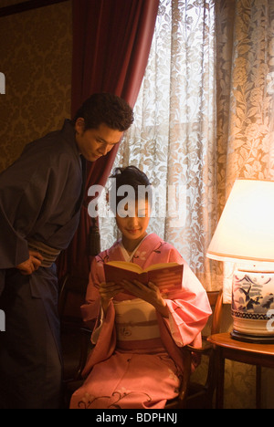 Junges Paar in Kimono Buch suchen Stockfoto