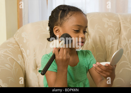 Hispanischen Mädchen Auftragen von Puder kompakt auf ihrem Gesicht Stockfoto