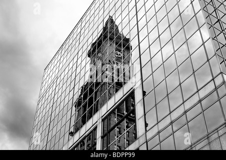 Die Reflexion einer alten Kirche in einem modernen verglasten Gebäude Stockfoto