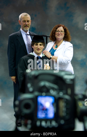 Ein Uni-Absolvent ist mit seinen Eltern anlässlich der glücklichen Anlass fotografiert. Stockfoto