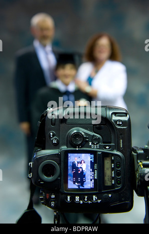 Ein Uni-Absolvent ist mit seinen Eltern anlässlich der glücklichen Anlass fotografiert. Stockfoto