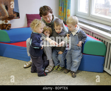 Kinder im Kindergarten Klasse ein Bilderbuch lesen. Stockfoto