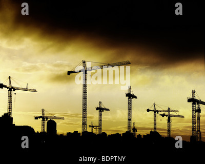 Bau Krane gegen gelbe Gewitterhimmel eingestellt Stockfoto