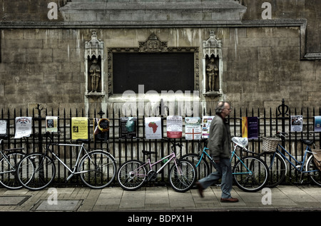 Ein Mann mittleren Alters zu Fuß entlang einer Straße in Cambridge, England, vorbei an einer Reihe von Fahrrädern Stockfoto