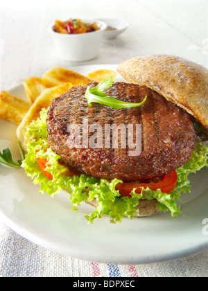 Beef-Burger in einem Vollkorn Brötchen mit Salat und Pommes frites Stockfoto