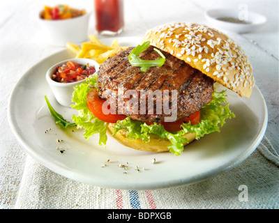 Char gegrilltes Rindfleisch-Burger mit Pommes Frites und Salat und ein Seseme Brötchen Stockfoto