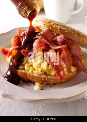 Knusprigem Speck und Rührei auf einen Bagel mit brauner Soße Stockfoto