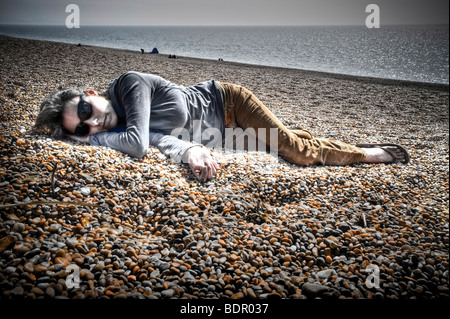 Eine Frau, die am Strand liegen Stockfoto