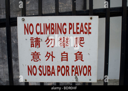 Ein Schild mit der Aufschrift keine Klettern bitte in Englisch, veröffentlicht Chinesisch und Spanisch auf einen Zaun in Chinatown in New York Stockfoto