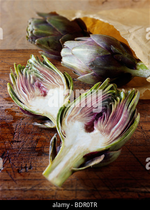 Die Side Shot frische Artischocken (Cynara Cardunculus) gegen einen Holz Hintergrund Stockfoto