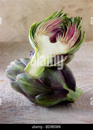 Die Side Shot frische Artischocken (Cynara Cardunculus) gegen einen Holz Hintergrund Stockfoto