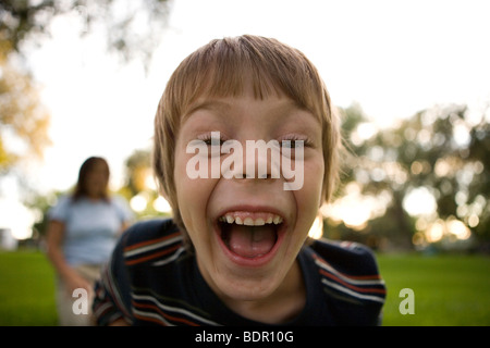 sechs Jahre alter Junge hysterisch lachend in die Kamera Stockfoto