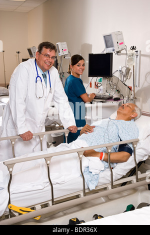 Arzt und Krankenschwester mit Patienten im Aufwachraum Stockfoto