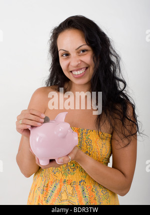 Hispanic Frau hält ein Sparschwein Stockfoto