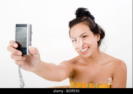 Frauen, die ihr eigenes Bild mit dem Handy über weiß Stockfoto