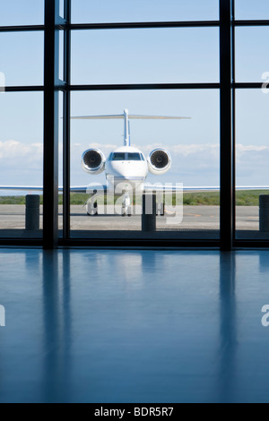 Ein kleiner Zwilling engined corporate Privatjet wartet draußen ein Flughafenterminal. Stockfoto