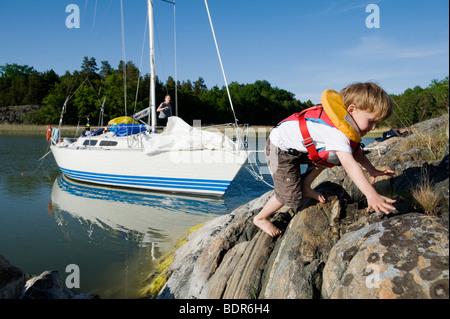 Ein Junge, Klettern auf einer Klippe Schweden. Stockfoto